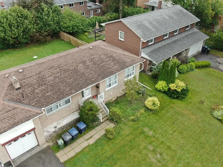 Aerial photograph showing a house roof, front entrance, driveway and garden.